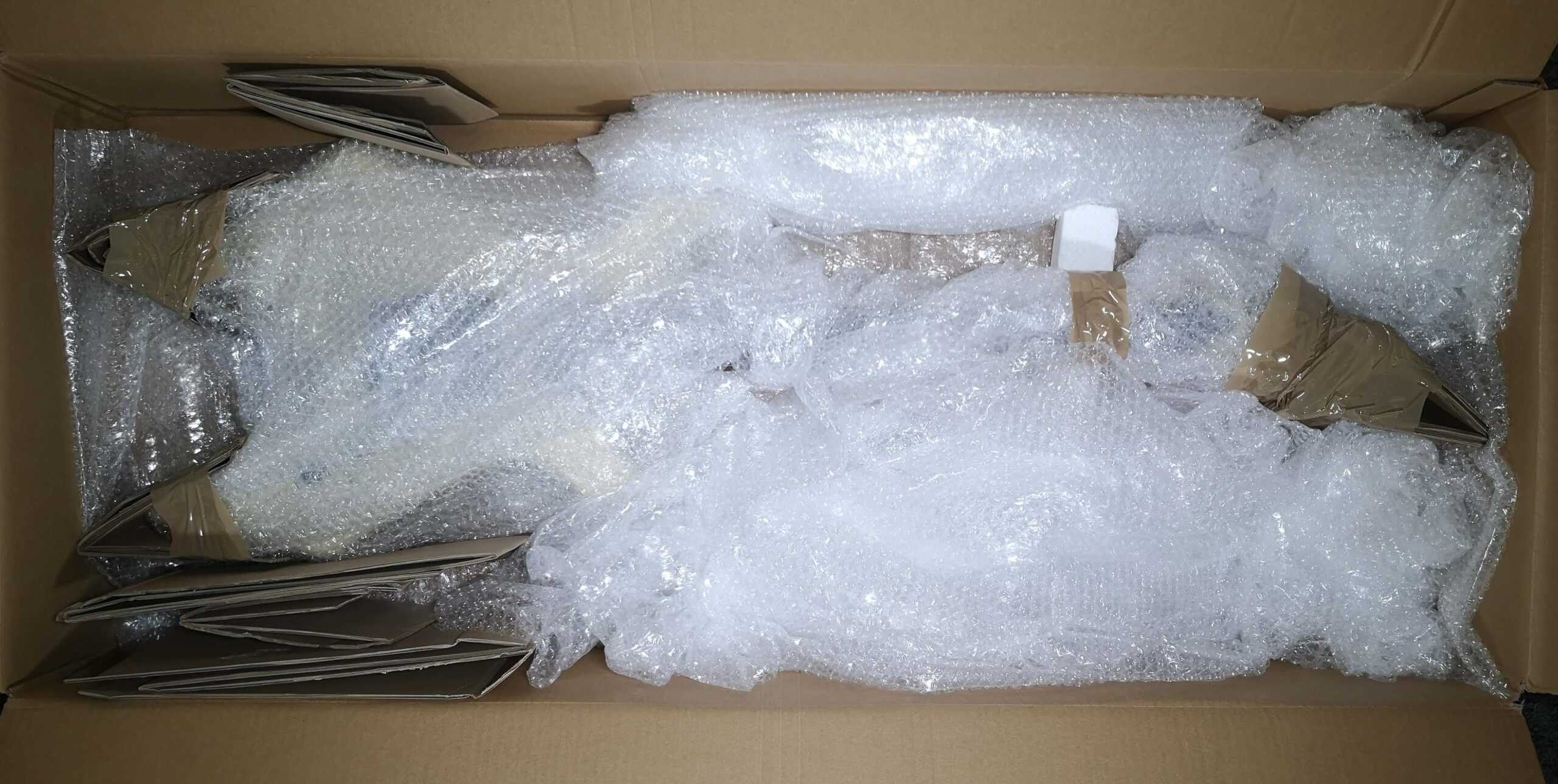 Gepolsterte Gitarre und mit Polstermaterial gefüllter Gitarrenkarton.