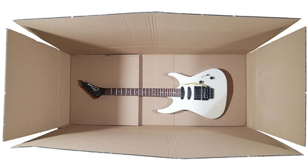 Blick in einen geöffneten Gitarrenkarton mit innenliegender Gitarre. Noch ungepolstert.
